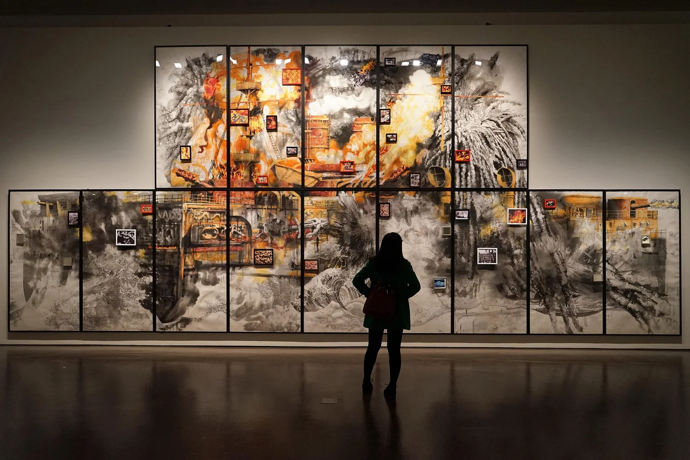 展厅里，一个人站在大幅作品前把细节看成整体